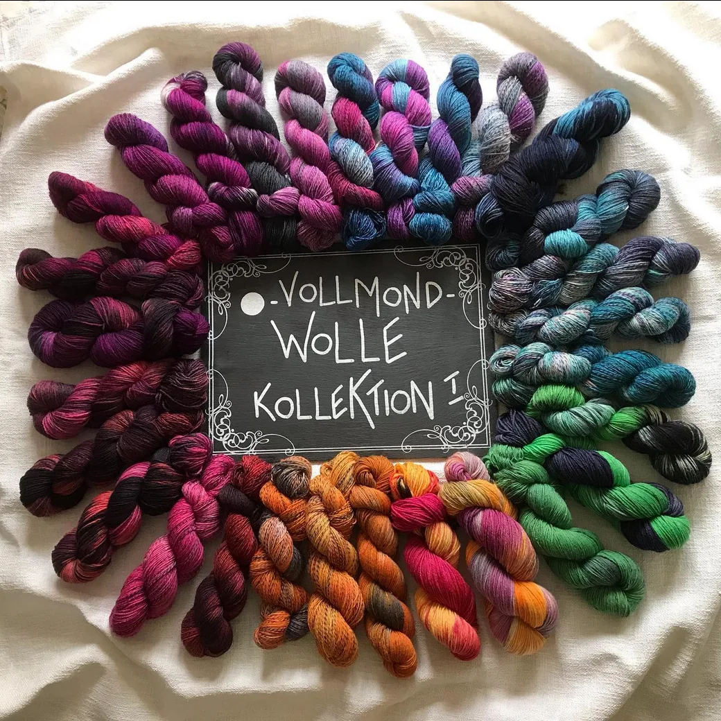 Vollmondwolle-Kollektion: Stränge in Beere, Violett, Petrol und Orange im Kreis gelegt